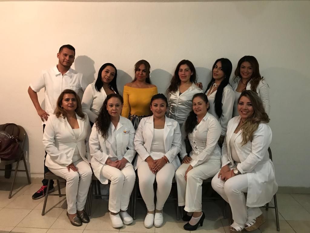 Grupo de alumnos y alumnas de blanco, sentados y de pie