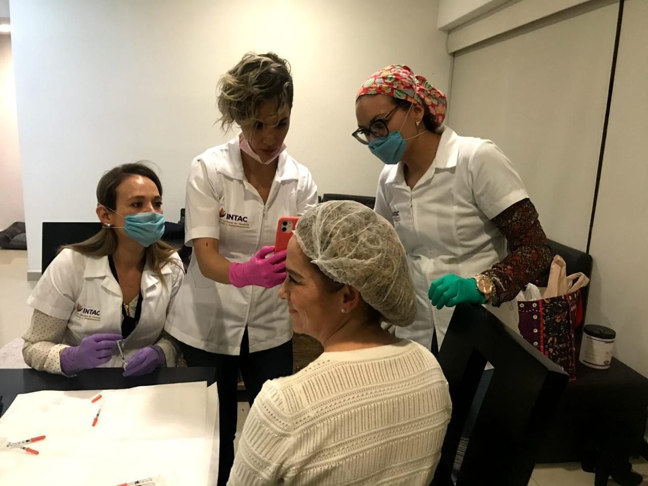 Tres docentes con bata INTAC acompañando una práctica